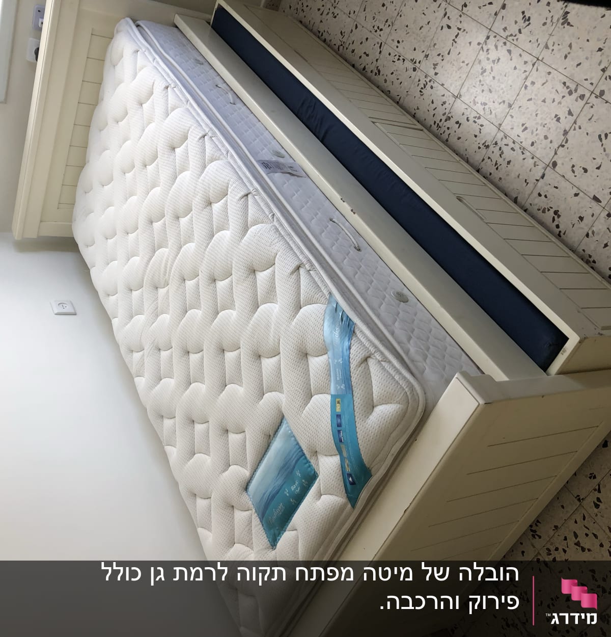 מזרן מונח על מיטה בחדר ריק עם רצפת אריחים